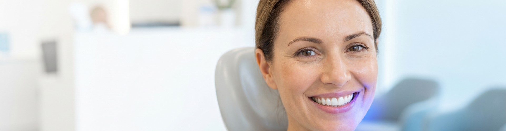 Smiling woman sitting in dental chair.